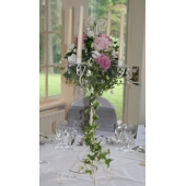 Aqua and Sweet Avalanche roses, bouvardia, lisianthus and veronica with mixed foliage and trailing ivy candelabra