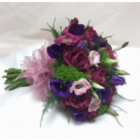 Blueberry rose, lisianthus and trachelium with asparagus fern, enhanced with a colour coordinated voile ribbon bow.