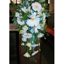 Gerbera and lisianthus pew end with coordinating foliage enhanced with teal bows.