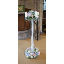 Tall candelabra with Sweet Avalanche rose, hydrangea, lisianthus and gypsophila with coordinating foliage enhanced with LED candles.