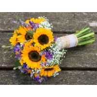 Sunflower, cornflower, limonium and gypsophila with coordinating foliage and bound with hessian and lace ribbon.