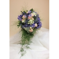 Agapanthus, freesia, spray rose and gypsophila with trailing asparagus fern bound with coordinating voile ribbon.