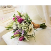 Tulip, lisianthus, freesia and gypsophila with asparagus fern and panicum grass enhanced with rustic binding