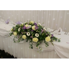 Avalanche rose, germini, freesia, lisianthus and veronica with coordinating foliage.