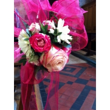 Sweetness rose and gerbera pew end with coordinating foliage enhanced with cerise voile.