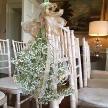 Gypsophila chair end enhanced with voile ribbon.
